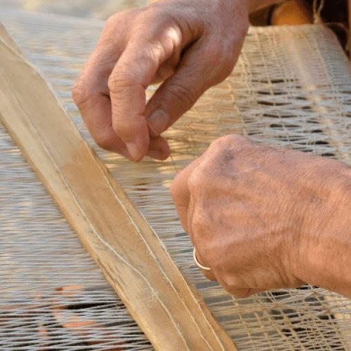 A person's hands doing weaving