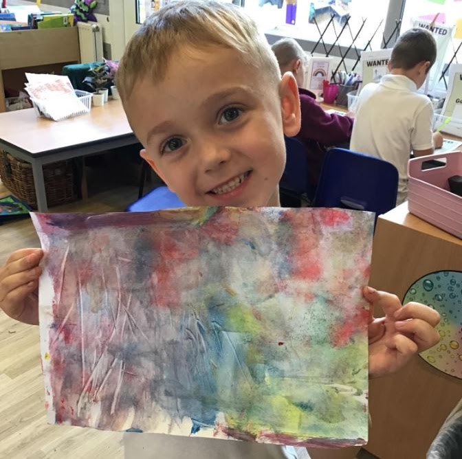 Smiling boy showing his completed painting