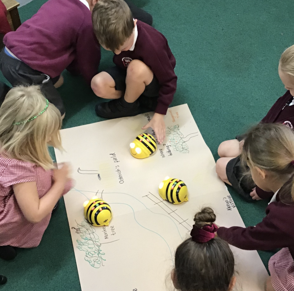 A group of children using programmable robotic bee devices
