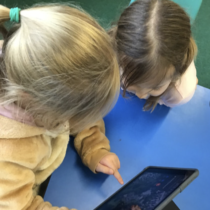 Two young girls using a tablet device
