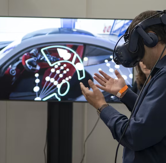 A person wearing a virtual reality headset in front of a computer
