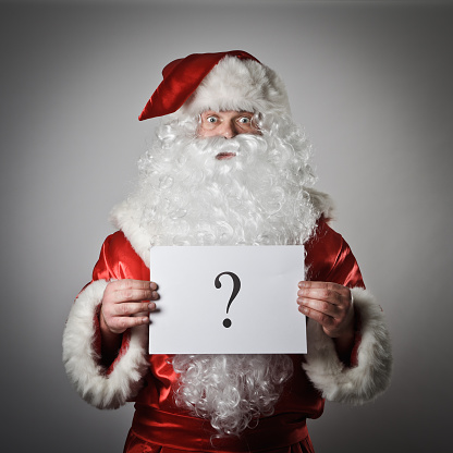 Santa holding a white card with a question mark on it
