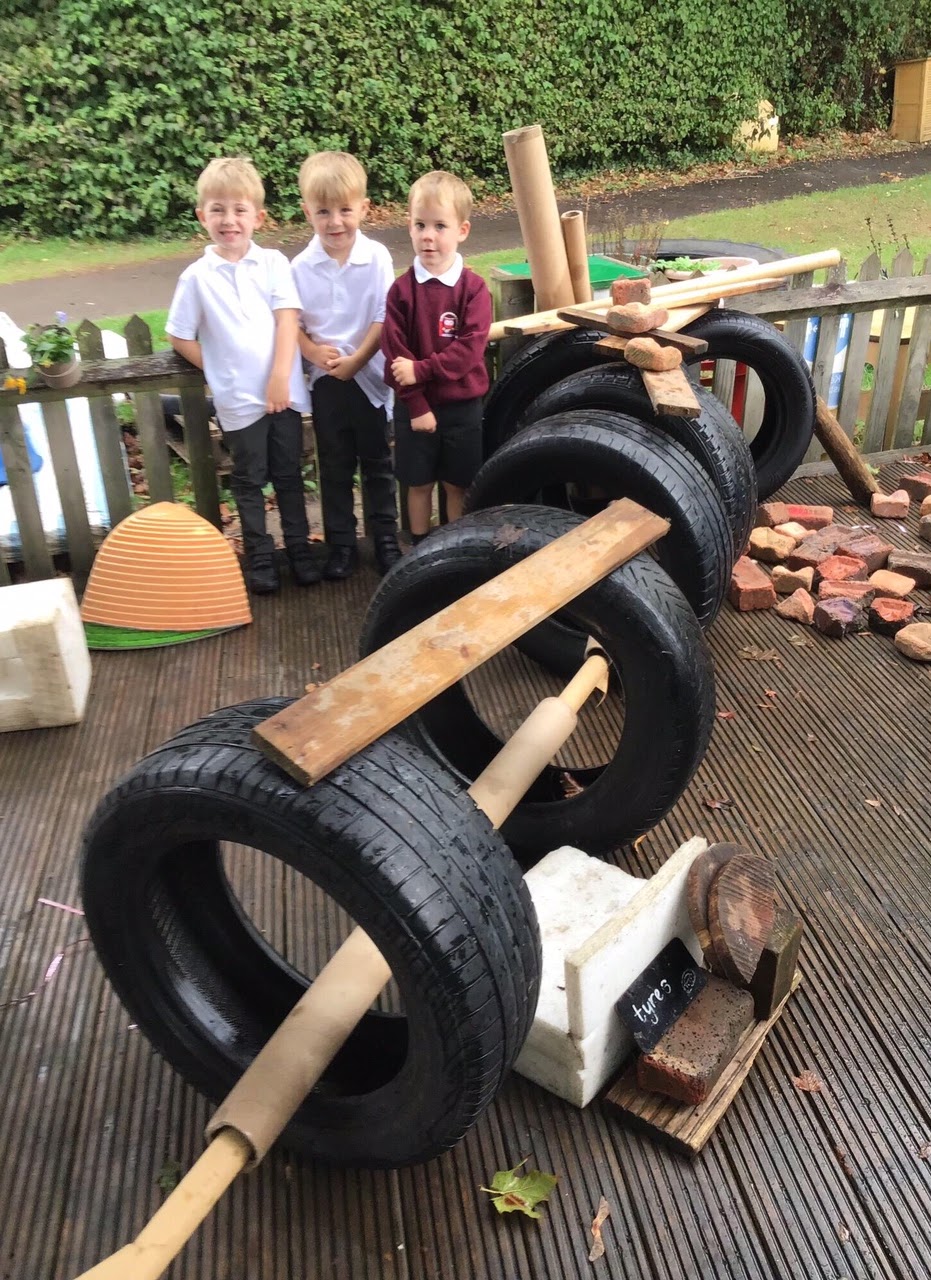 Children building a structure from tyres and planks