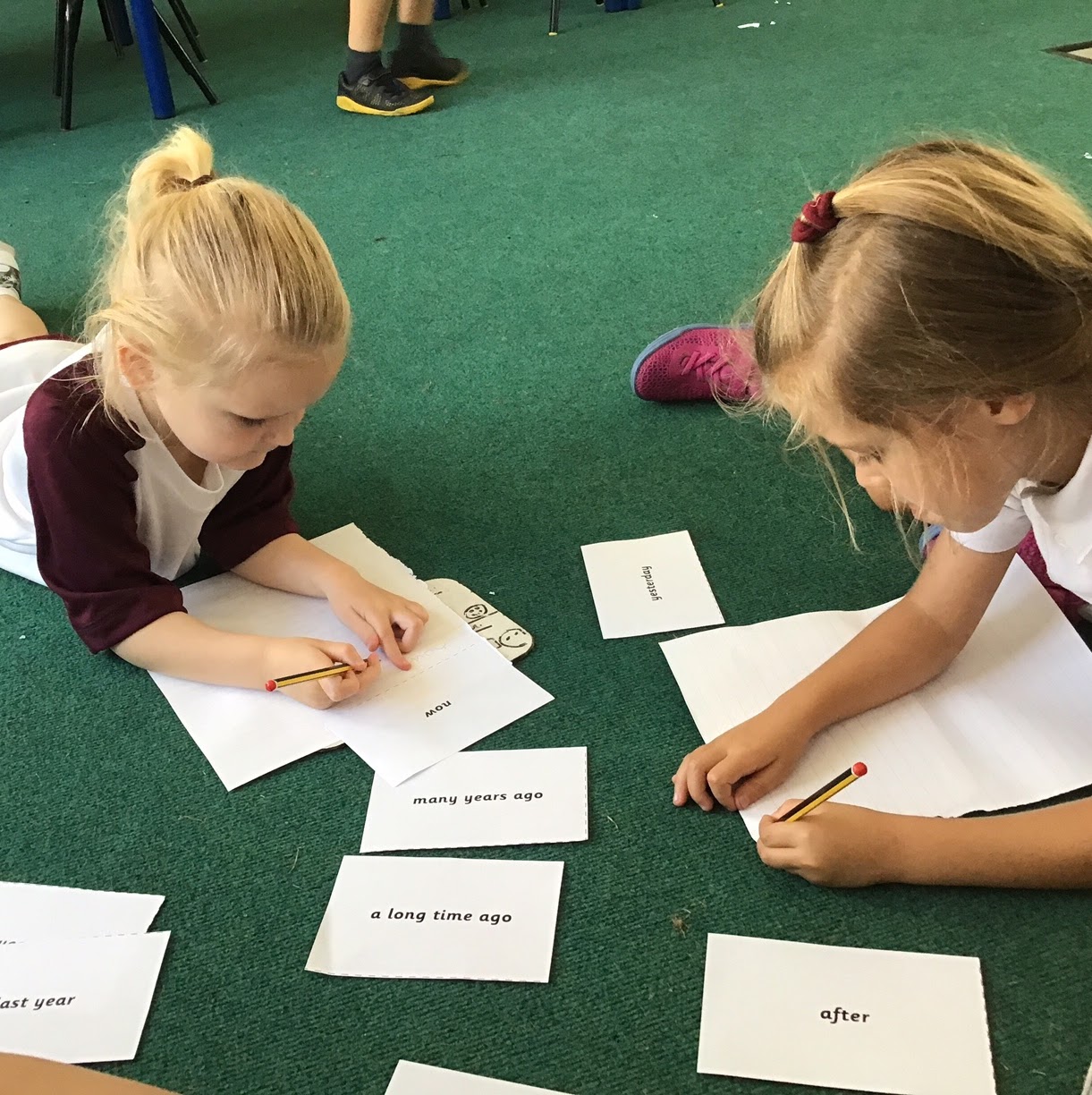 Children working from reading cards on the floor