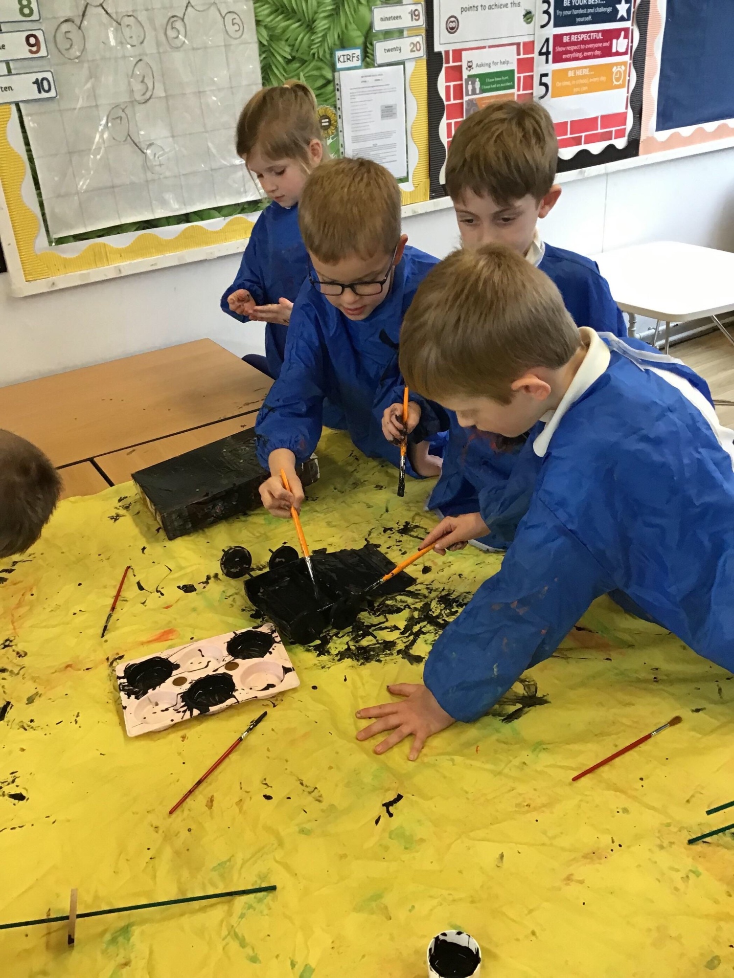 A group of boys painting an object