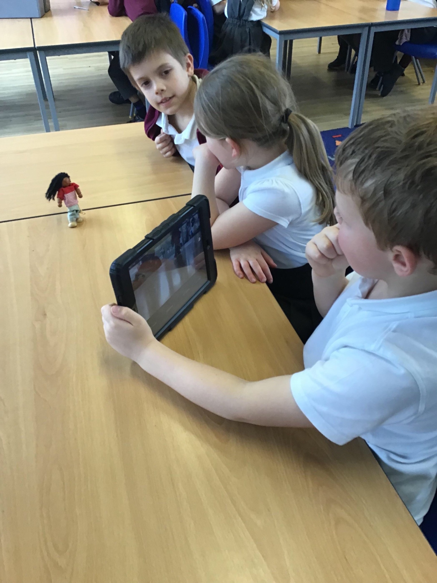 A group of children using a tablet device