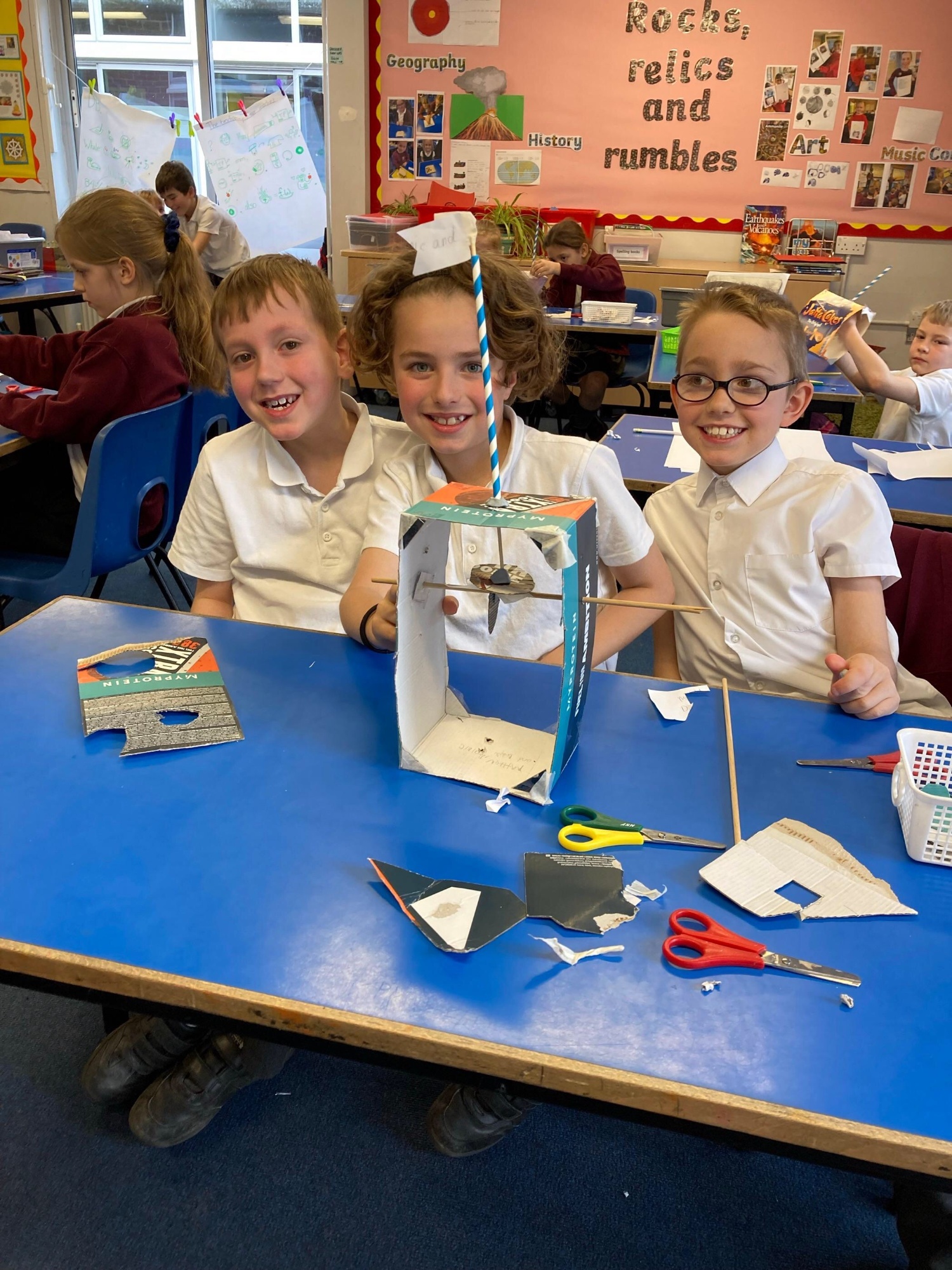 Smiling children with a model they have made together