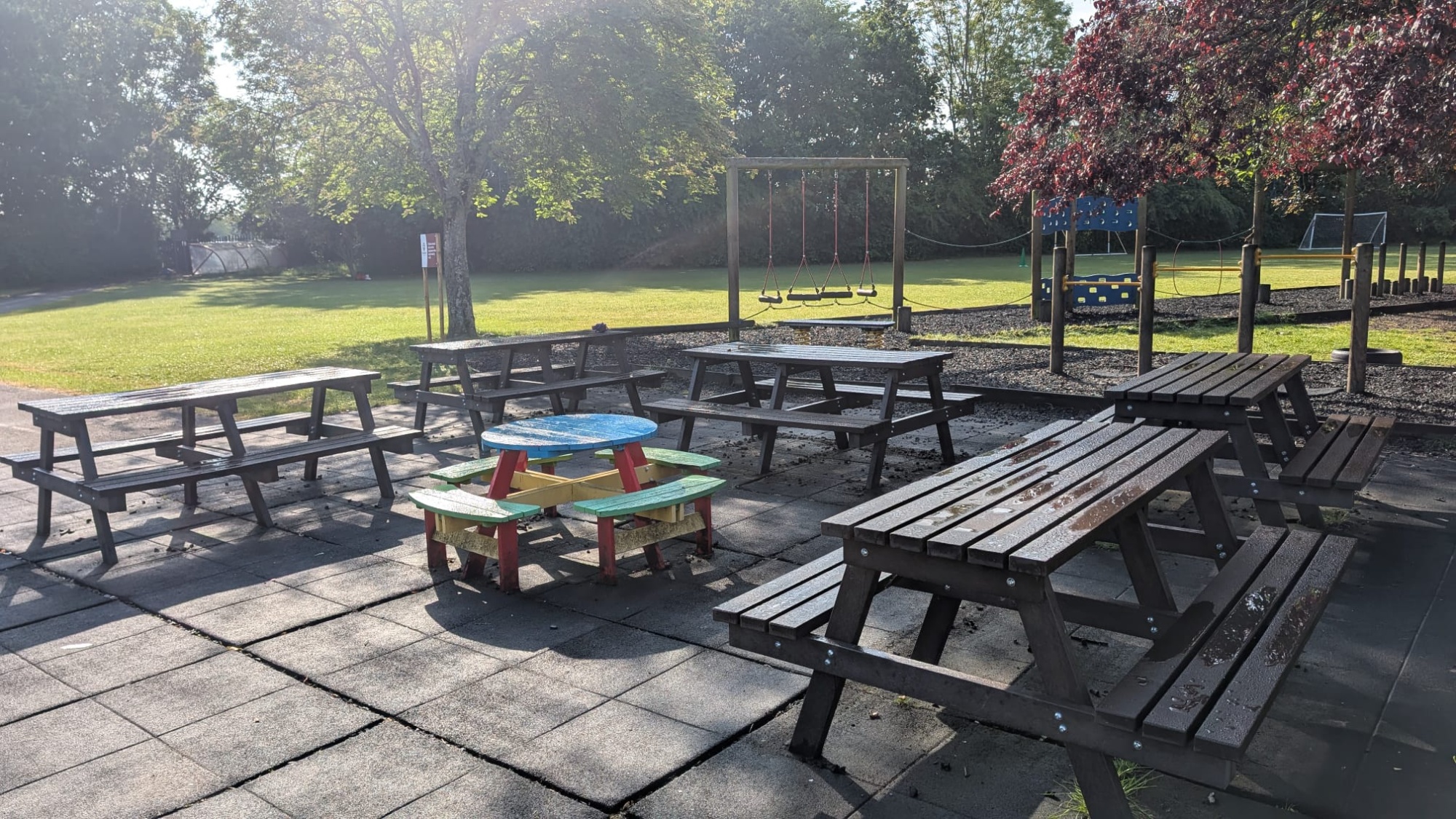 Picnic benches and a play park in the background